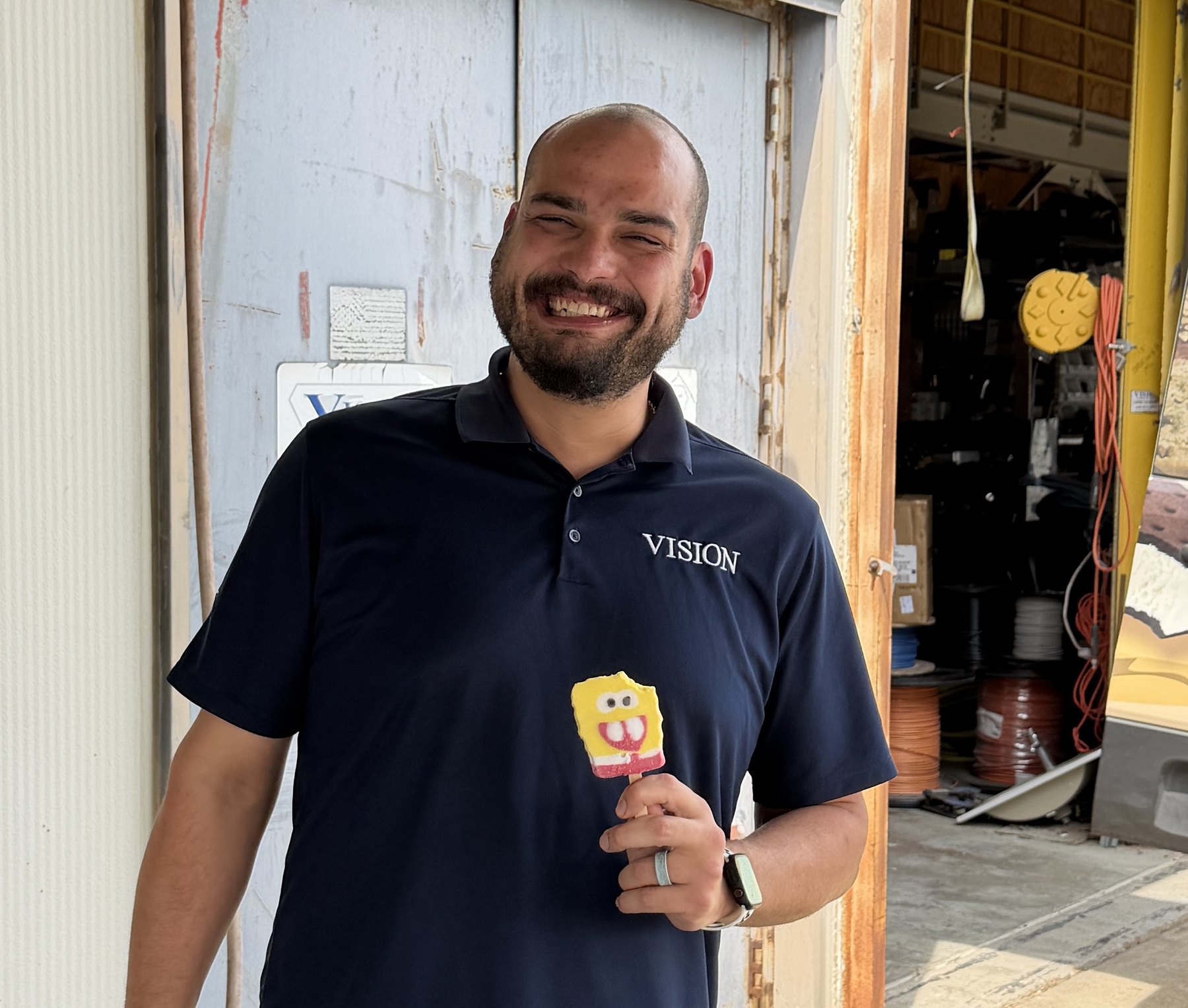 A smiling VISION employee holding an ice cream treat