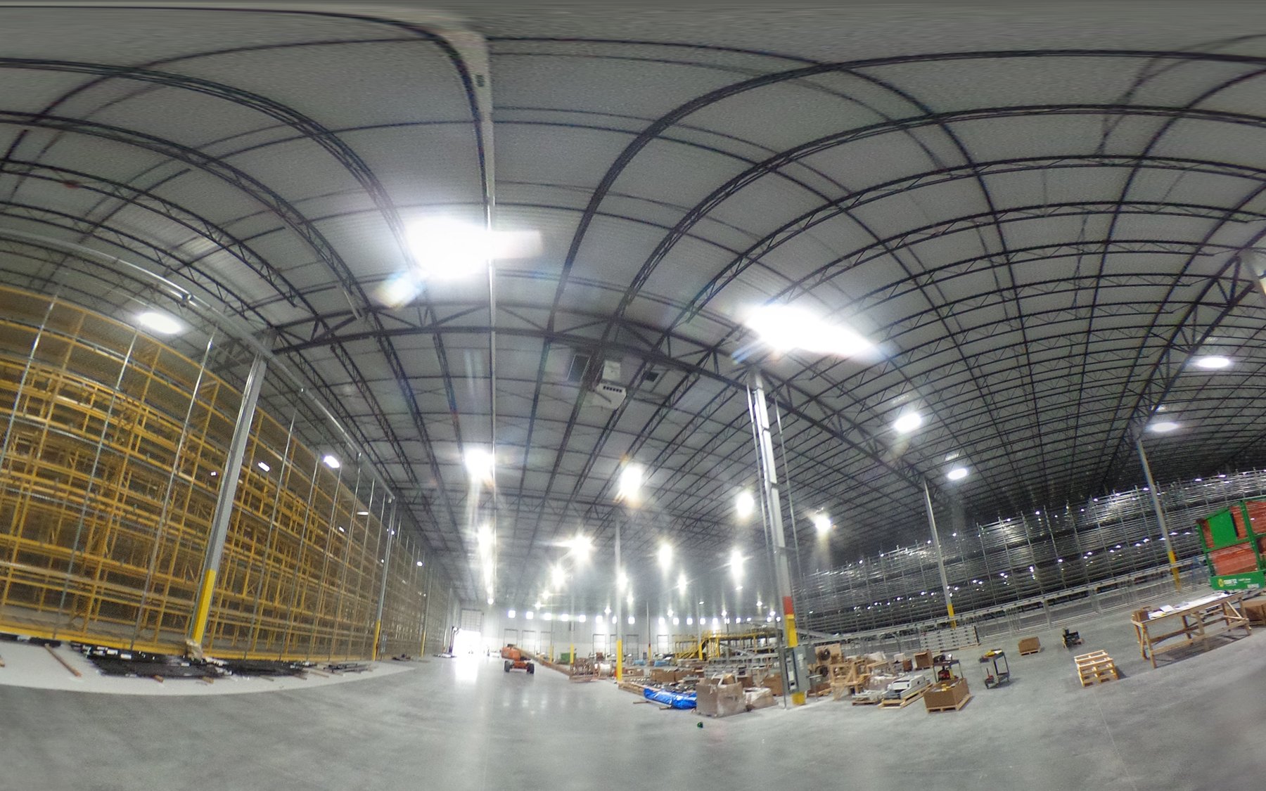 Active lift work beneath completed warehouse lighting at the ACE distribution center